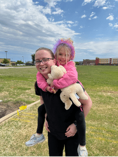 Starr giving a piggyback ride to a young patient.