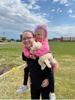 Starr giving a piggyback ride to a young patient.