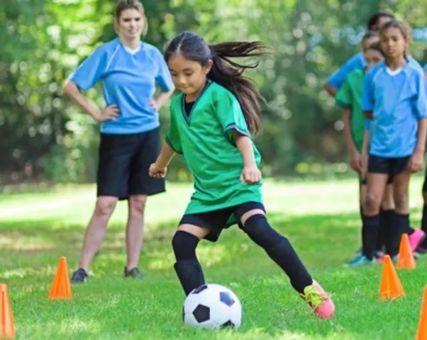 Girl playing soccer in grass