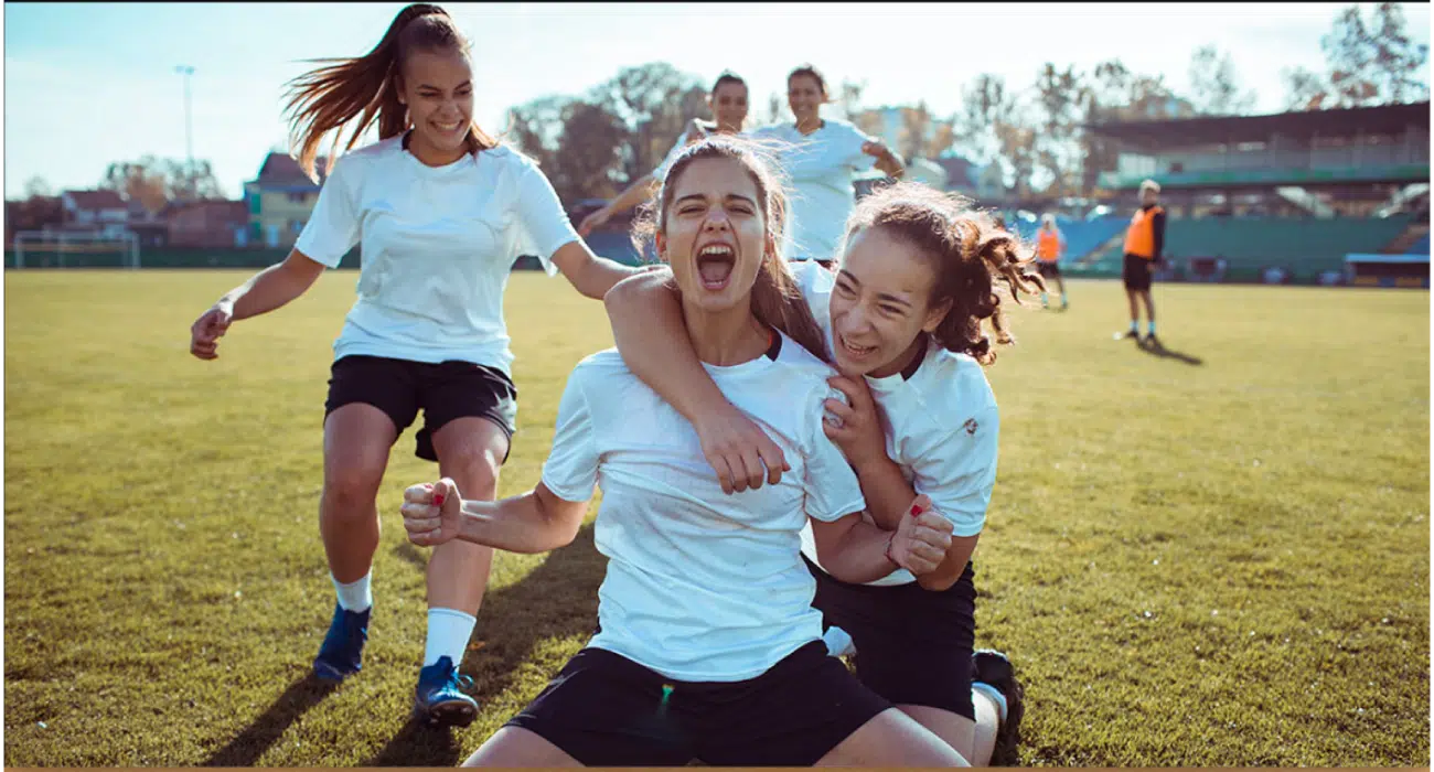 Girls celebrating a goal during a soccer match